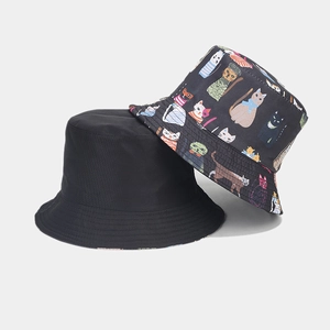 Close-up of double-sided bucket hat featuring cute cartoon cat prints and black lining