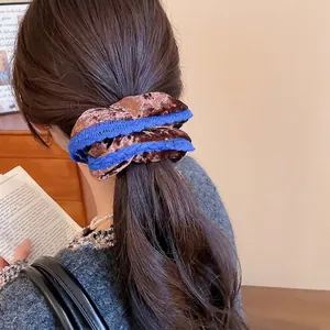 Velvet hair scrunchie with lace trim shown on woman hair in a cozy home setting