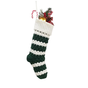 Knitted green and white striped Christmas stocking with bubble texture on white background