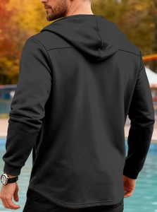 Detail of men's black hooded jacket showing knitted texture and curved hemline