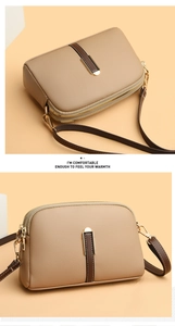 Detail view of khaki shell bag with litchi texture and dual zipper compartments