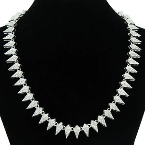 Close-up of geometric triangle chain links with pavé crystals on a black bust