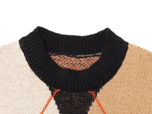 Detail of knit sweater crewneck showing diamond pattern stitching and ribbed collar finish