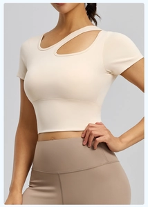 Dettaglio del crop top da yoga bianco crema con scollatura asimmetrica e tessuto elastico