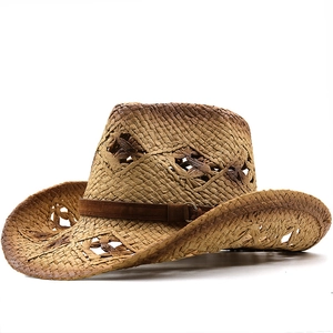 Détail d'un chapeau de cowboy en paille avec étoiles évidées et ceinture en cuir brun