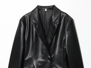 Detail of classic notched lapel on a black faux leather blazer with matte texture