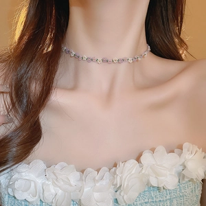 Close-up of handmade bead flower choker necklace in pastel purple, white, and green tones