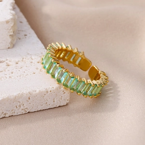 Detail of an adjustable gold ring featuring rectangular emerald-cut green zircon stones