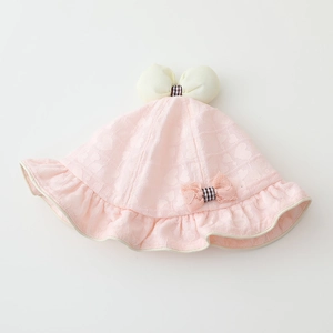 Détail d'un chapeau de soleil pour bébé avec dentelle à cœurs et gros nœud