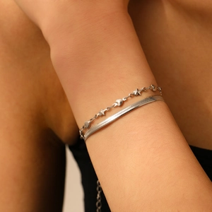 Détail du bracelet double en acier inoxydable argenté avec pendentifs cœur et étoile