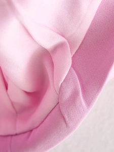 Détail de la texture du tissu rose doux et des coutures précises du haut ajusté femme