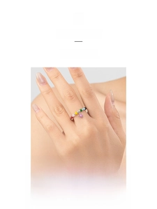 Detail of colorful beaded flower ring with pink petal charm on model finger