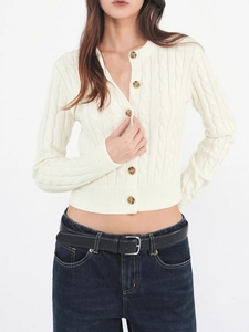 Close-up of cable knit wool cardigan detail showing white texture and dark buttons