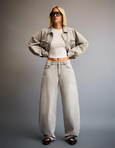 Detail of high-waisted wide-leg denim jeans and cropped jacket in light washed grey