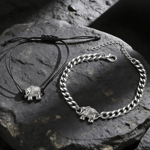 Detail of elephant charm bracelets with silver cuban chain and black woven cord