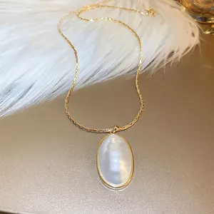 Collier vintage français avec pendentif ovale en perle dorée sur fourrure blanche