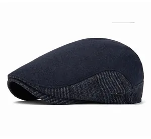 Detail of navy blue wool flat cap showing textured plaid pattern and metal brand emblem