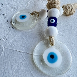 Macro detail of handmade evil eye charms with glass pendants and natural hemp rope