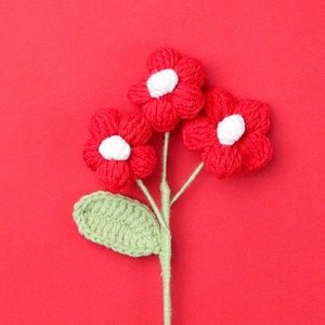 Close-up of handmade crochet puff flowers with detailed red petals and white centers