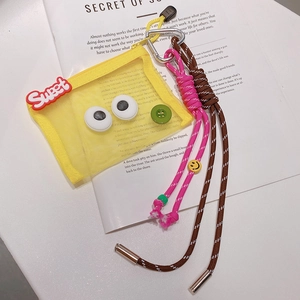 Détail de la pochette en maille jaune avec texte Sweet, cordes tressées et perles