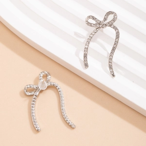Detail of silver bow earrings with sparkling rhinestones and elegant ribbon design