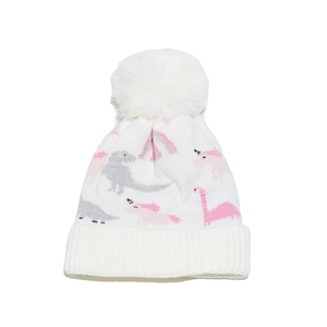 Close-up of white knit hat with fluffy pompom and cute pink cartoon dinosaur pattern