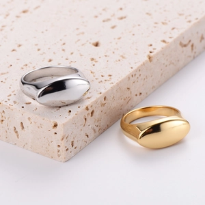 Minimalist polished metal rings in gold and silver finish on a travertine stone