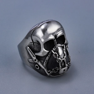 Macro shot of punk style stainless steel skull mask ring with chain detail on gray background