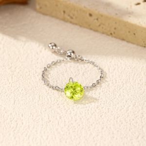 S925 silver chain ring with olive green gem pendant on a textured stone background
