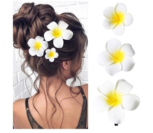 Detailed views of various sized white and yellow plumeria hair clips for beach styling