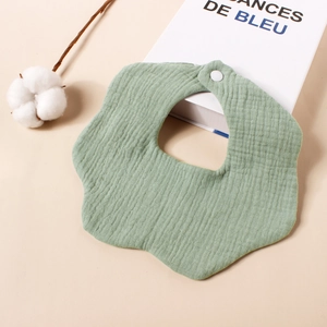Detail van een zachte baby slabbetje in bloemvorm van 6-laags katoenen mousseline