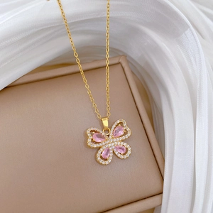 Detailed close-up of a gold butterfly necklace featuring pink marquise stones and crystals