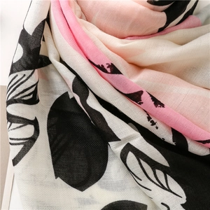 Detailed macro view of tropical floral print texture on a linen scarf with fringe