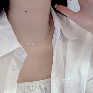 Close-up of S925 sterling silver beaded necklace on model wearing a white shirt
