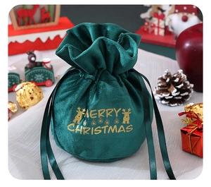 Detail of dark green velvet Christmas drawstring gift bag with gold reindeer and text
