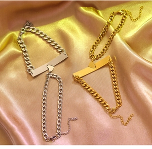 Detail of interlocking heart pendants on gold and silver Cuban chain bracelets