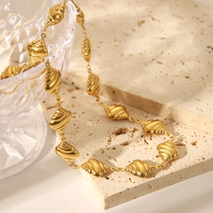 Dettaglio macro della collana con maglie a conchiglia placcata oro 18K su pietra