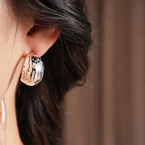 Minimalist silver geometric C-shaped earrings with irregular hammered texture on model