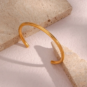 Detailed close-up of a minimalist 18K gold-plated stainless steel open bangle on stone bases