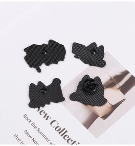 Detail of cartoon cat enamel pins back with rubber clutch and alloy texture on white magazine