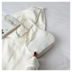 Close-up of white vertical textured shoulder bag with chic plastic chain detail