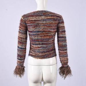 Detail of colorful striped knit crop top featuring elegant brown faux fur cuffs on sleeves
