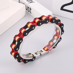 Detail of red and black motorcycle chain bracelet with gold pins and steel clasp