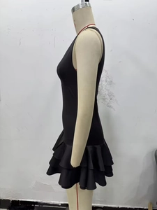 Detail view of tiered ruffles on a black sleeveless mini dress for a stylish look
