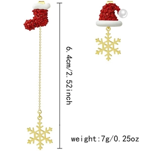 Détail de boucles d'oreilles de Noël asymétriques avec bonnet de Noël, chaussette et flocon