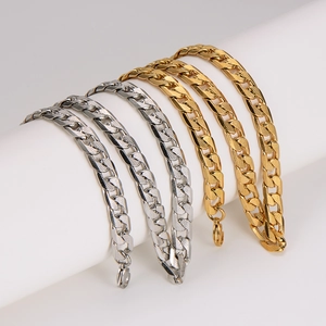 Textured Cuban link bracelets in gold and silver finish on white display stand