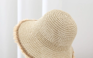 Detalle de la textura tejida a mano del sombrero de paja y el elegante borde deshilachado