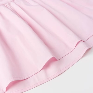 Detailed view of pink pleated hem showing smooth fabric texture and fine stitching