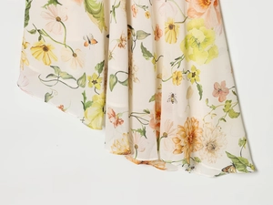Gros plan sur un tissu à imprimé floral avec des fleurs jaunes et pêches