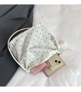Detail view of lace drawstring bag with black polka dots showing interior storage space